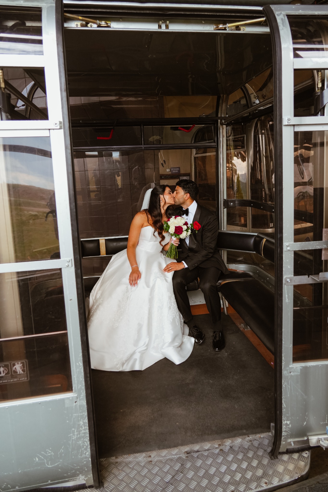 Bride and groom sharing a quiet moment inside a mountain gondola